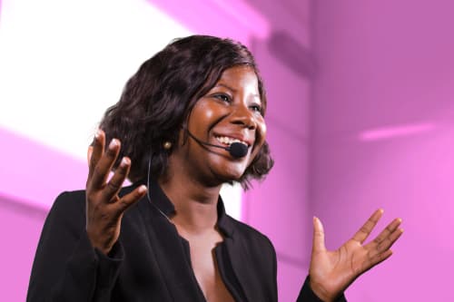 A speaker wearing a headset microphone addressing an audience